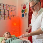 Energetiker Thomas Leitner arbeitet mit dem Tensor am Herzchakra einer Klientin